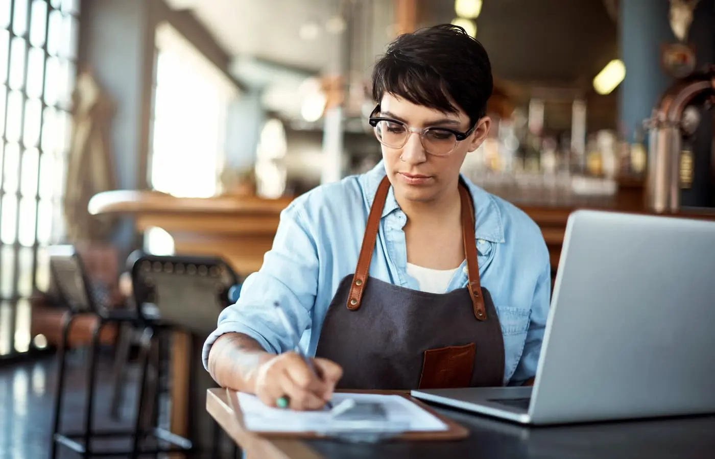 A business owner comparing insurance quotes and documents thoughtfully at a desk